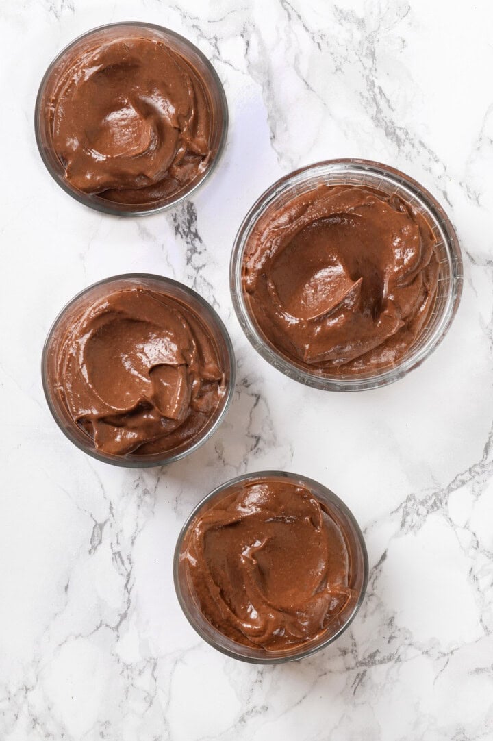 Overhead view of avocado chocolate mousse in 4 glass ramekins