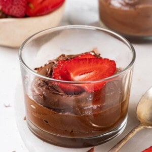 Vegan chocolate avocado mousse in 2 glass ramekins with berries