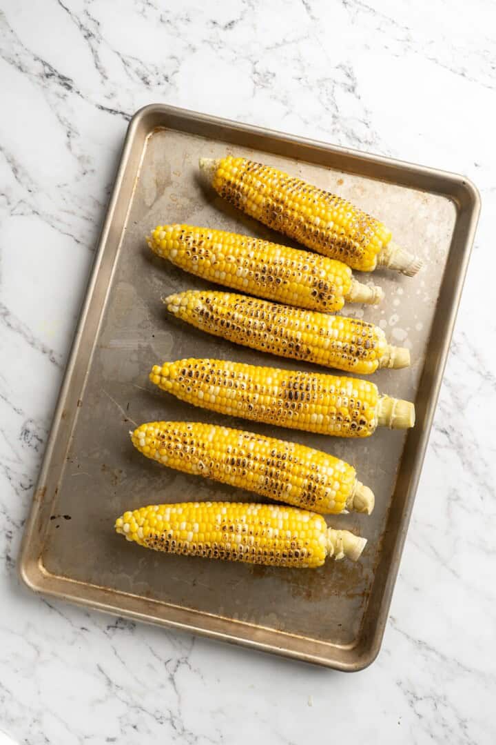 Overhead view of grilled corn on pan