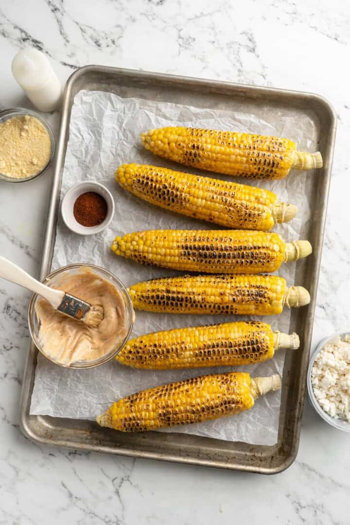 Overhead view of grilled corn on sheet pan