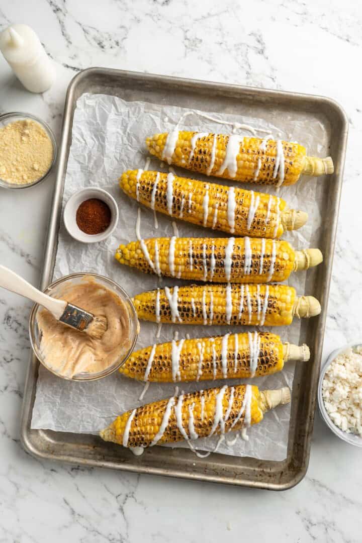 Overhead view of Mexican street corn drizzled with crema