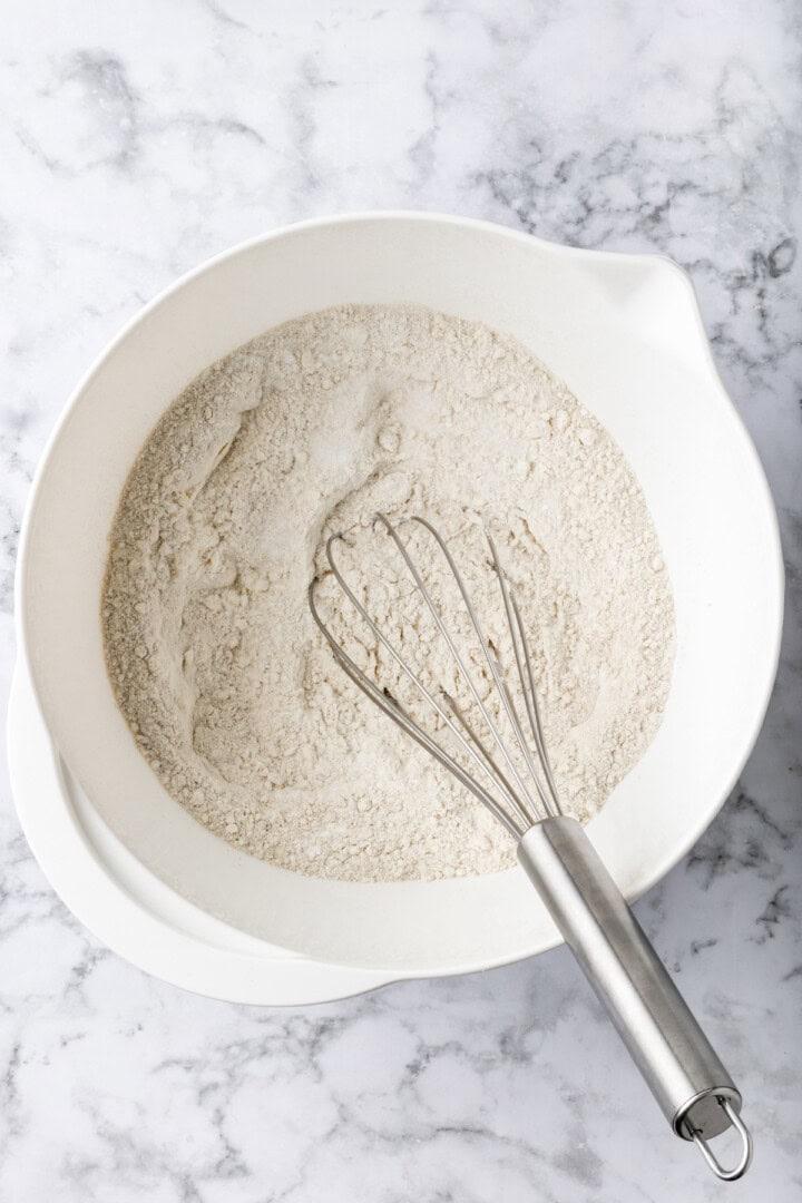 Overhead view of dry ingredients in mixing bowl with whisk