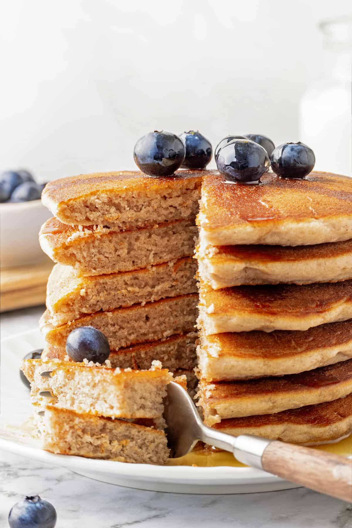 Stack of buckwheat pancakes with wedge cut to show fluffy, thick texture