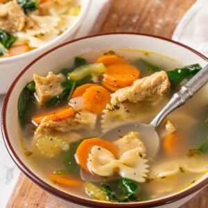 Vegan chicken noodle soup in bowl with spoon