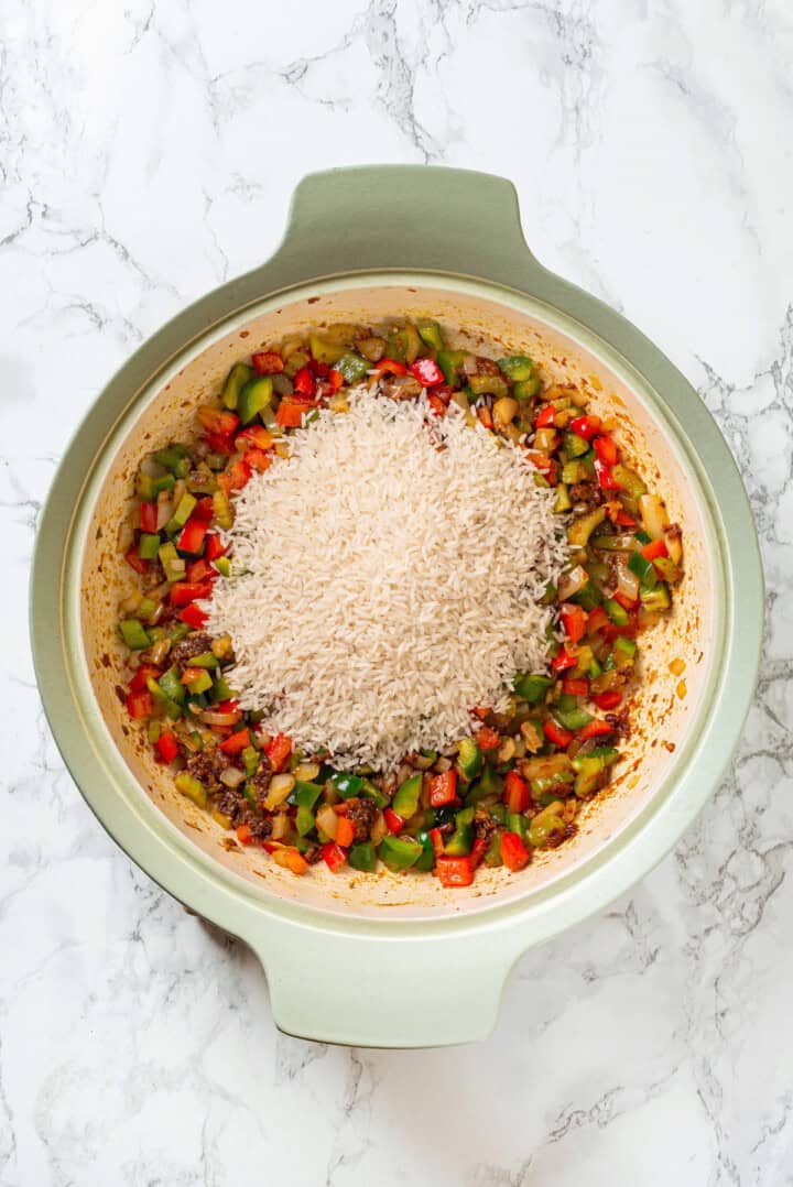 Overhead view of rice added to skillet of veggies