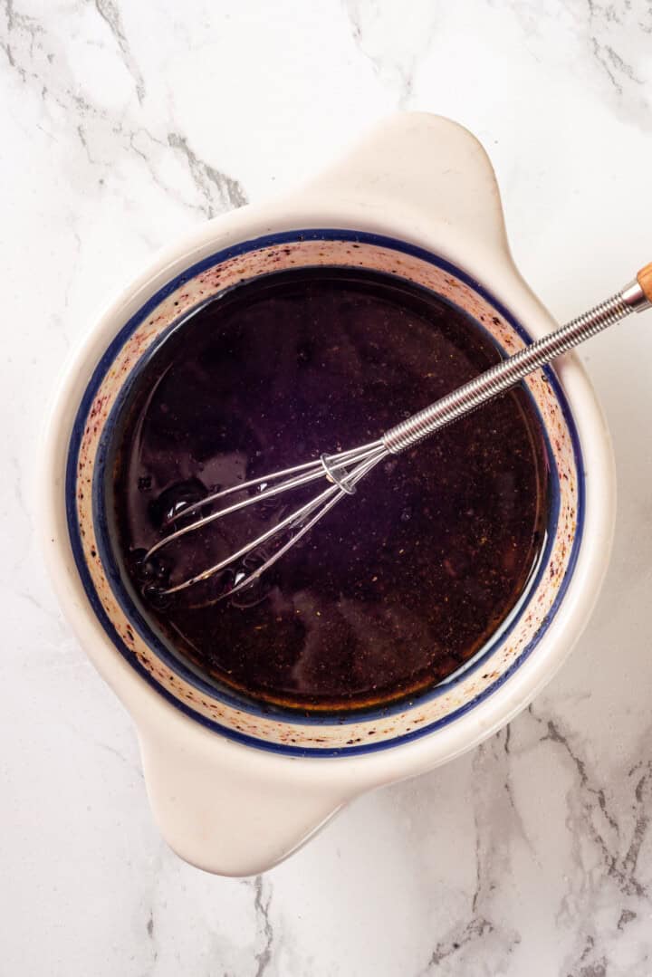 Dressing for fattoush salad in bowl with whisk