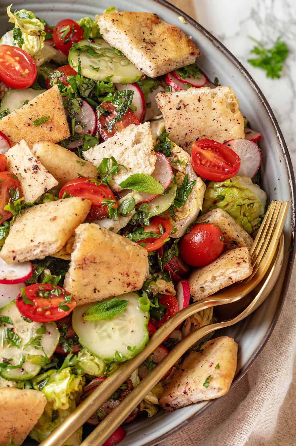 Bowl of fattoush salad with spoon and fork