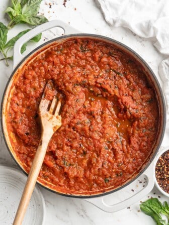 Overhead view of arrabbiata sauce in skillet with wooden spoon