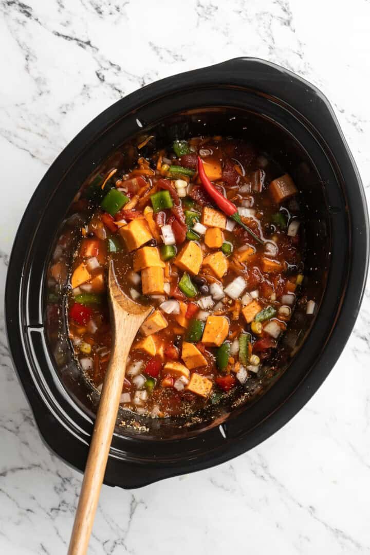 Overhead view of ingredients for sweet potato and black bean chili in slow cooker