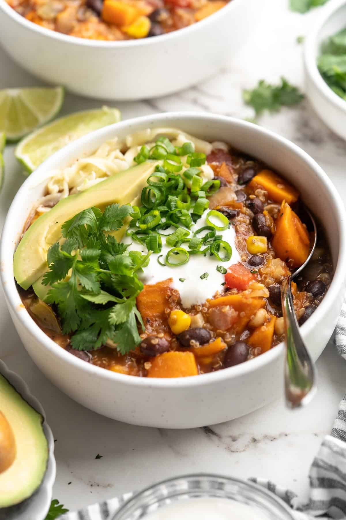 Bowl of sweet potato and black bean chili with garnishes