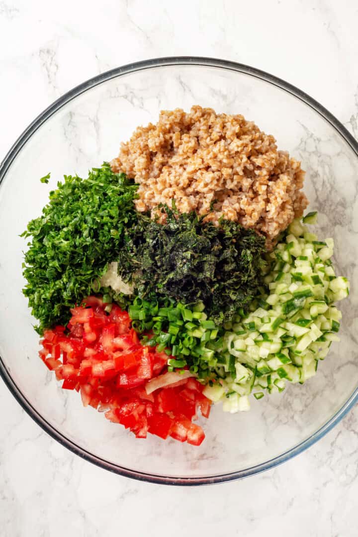 Overhead view of tabbouleh ingredients in mixing bowl