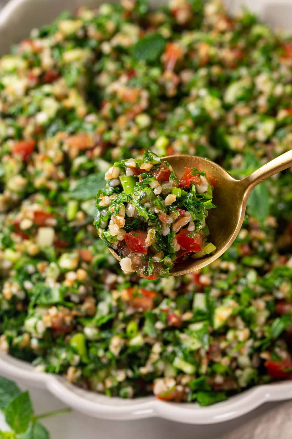 Spoonful of tabbouleh salad held over bowl