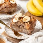 Two plates of banana bread pudding with bananas in background - 10