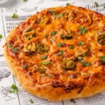 Unsliced birria pizza on marble board