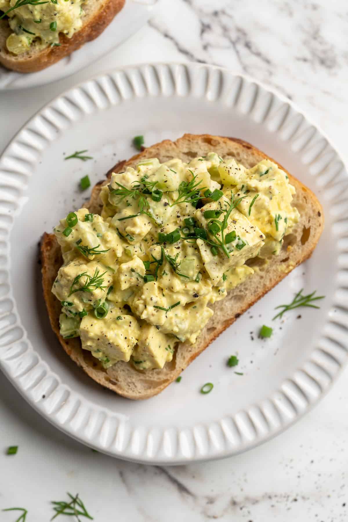 Overhead view of tofu egg salad on slice of bread