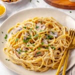 Vegan pasta carbonara on plate with fork and spoon