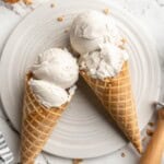 Overhead view of two vegan ice cream cones with vanilla ice cream on plate