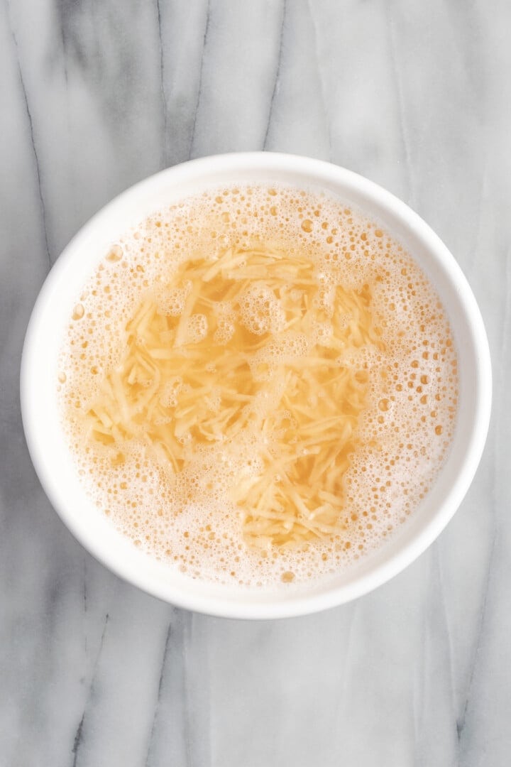 Shredded potatoes soaking in water