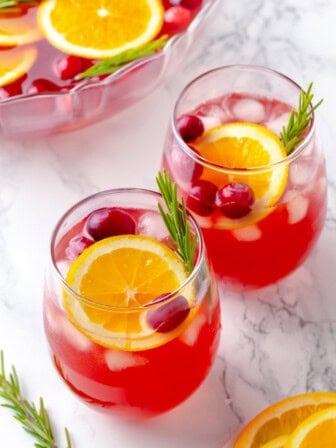 Two glasses of Christmas punch with garnishes