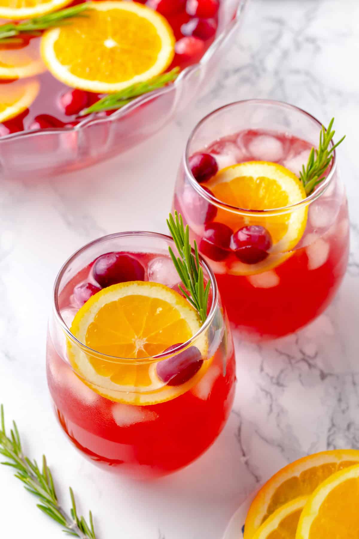 Two glasses of Christmas punch with garnishes