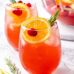 Two glasses of Christmas punch with bowl in background