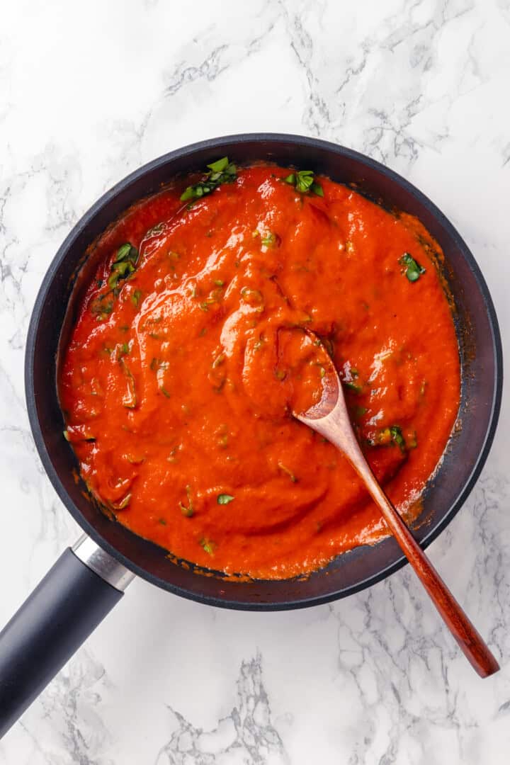 Overhead view of pomodoro sauce in skillet with wooden spoon