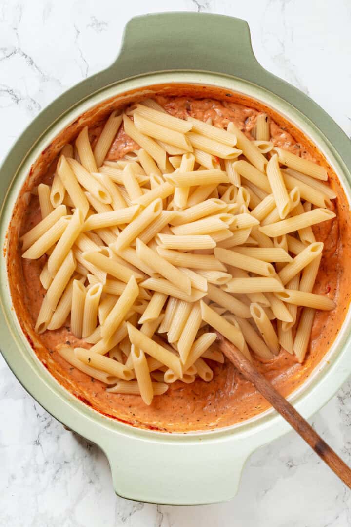 Stirring penne into sauce for marry me pasta