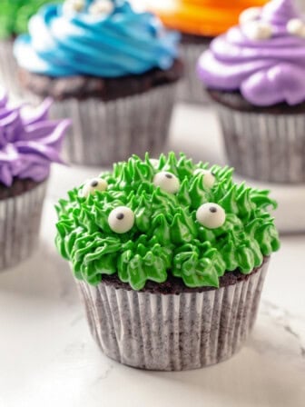 Green Halloween cupcake with additional cupcakes in background