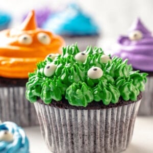 Green Halloween monster cupcake, with other colour cupcakes in background