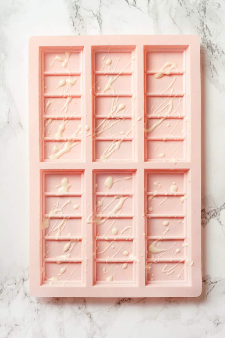 White chocolate drizzled into candy bar mold