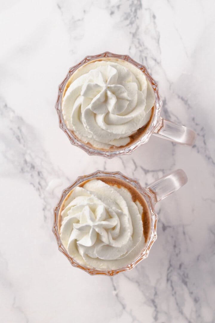 Overhead view of hot buttered rum topped with vegan whipped cream