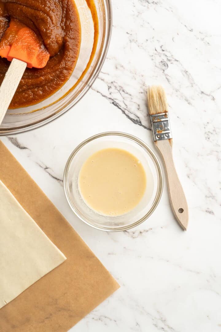 Vegan egg wash in small bowl with brush