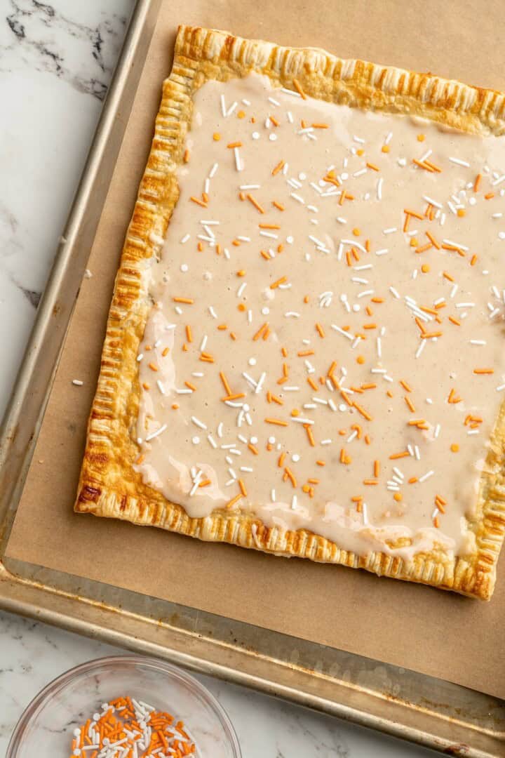 Giant pumpkin pop tart on baking sheet before cutting