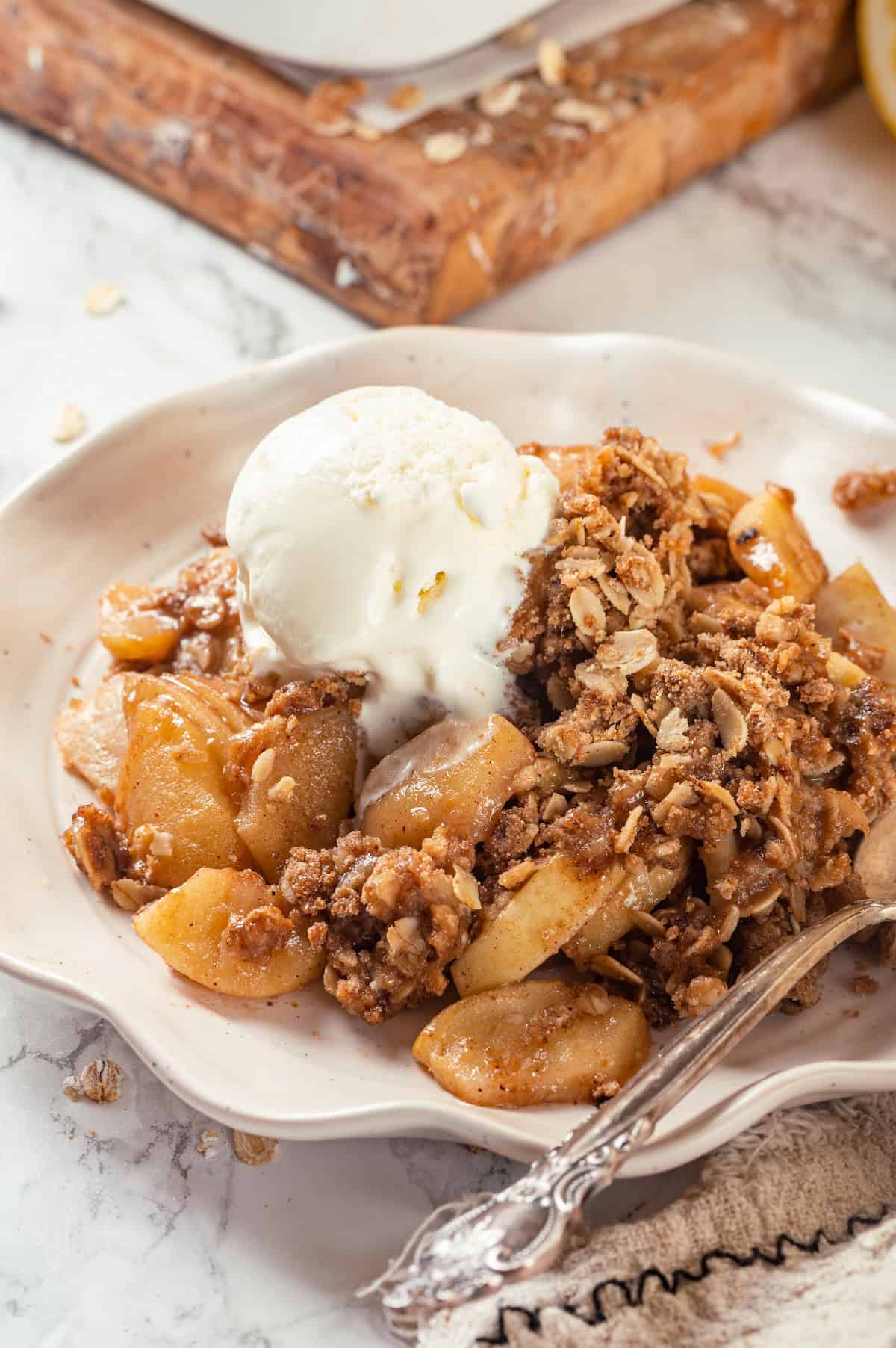 Vegan apple crisp on plate with ice cream