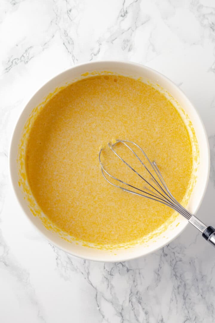 Corn pone batter in bowl with whisk