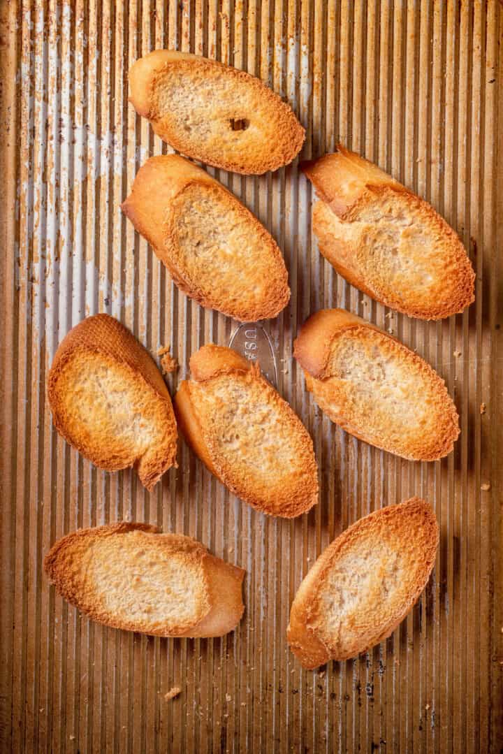 Overhead view of toasted baguette on sheet pan