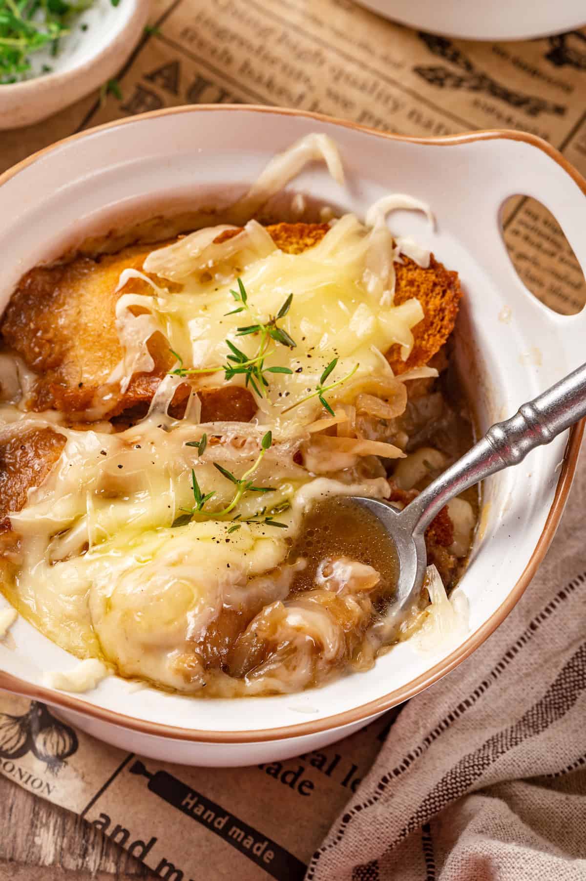 Vegetarian French onion soup in bowl with spoon