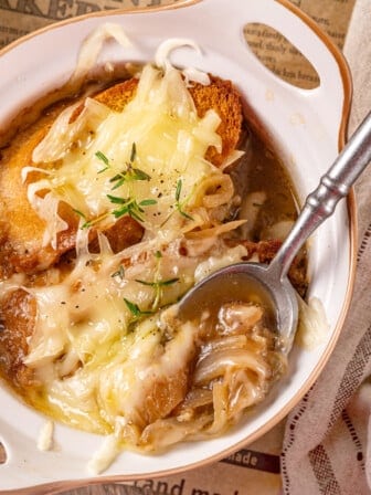 Overhead view of vegan French onion soup in bowl with spoon