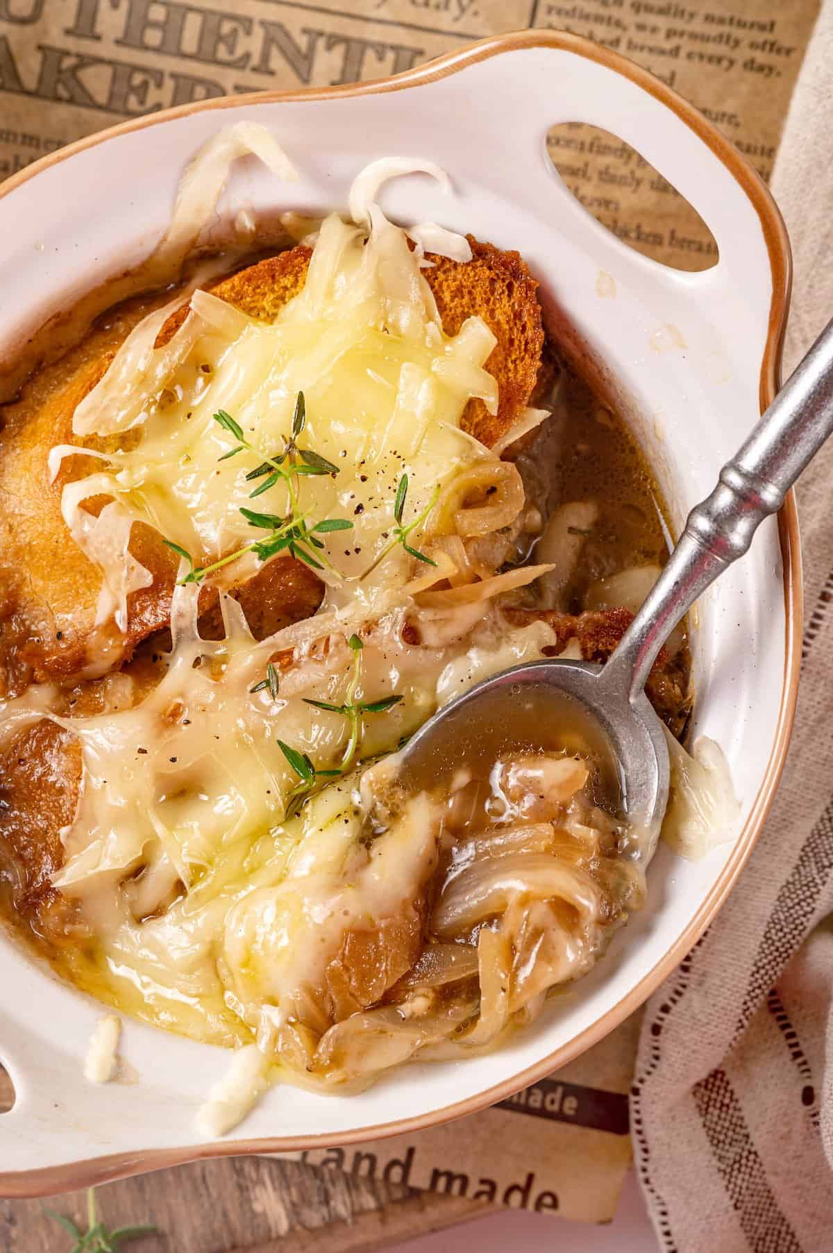 Overhead view of vegan French onion soup in bowl with spoon