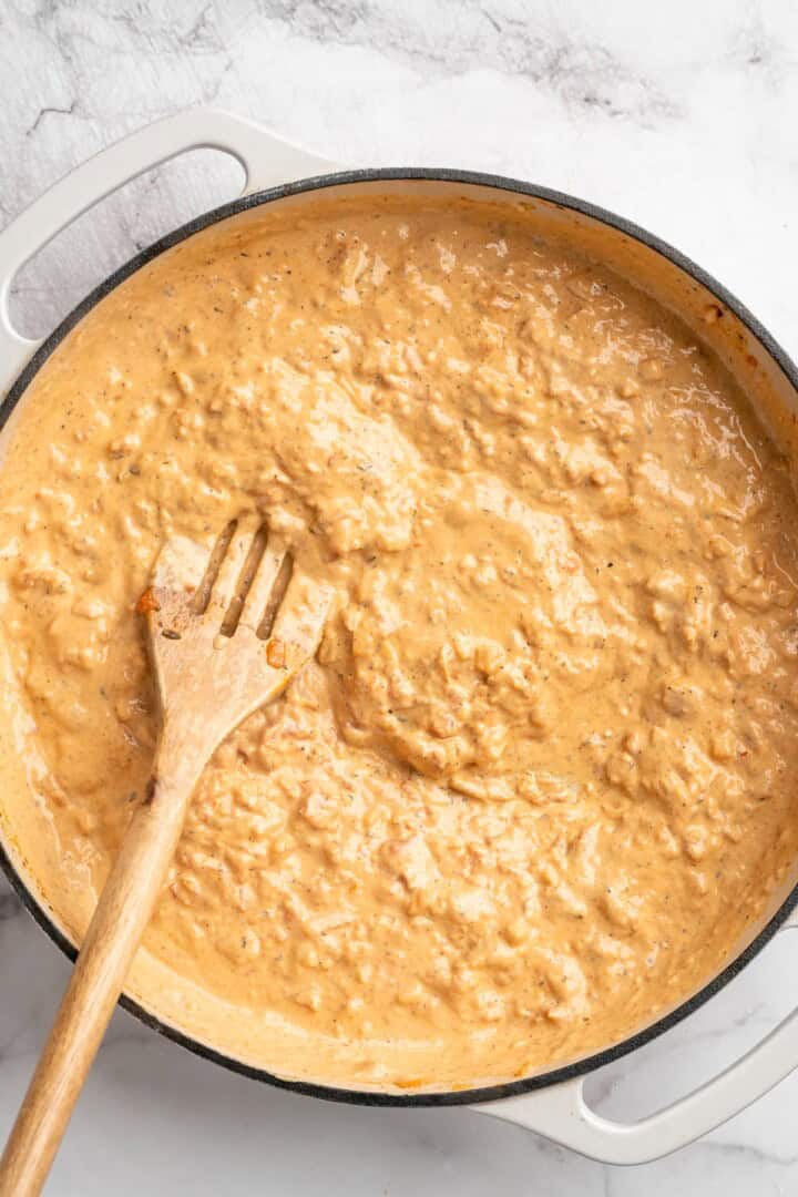 Overhead view of vegan marry me sauce in skillet with slotted spoon