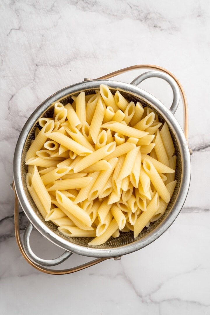 Overhead view of drained penne in colander