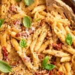 Overhead view of vegan marry me pasta in skillet with slotted spoon