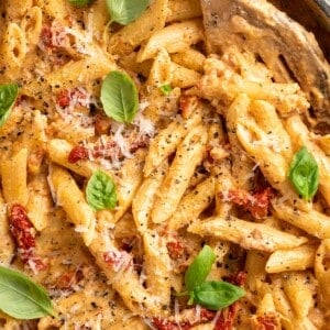 Overhead view of vegan marry me pasta in skillet with slotted spoon