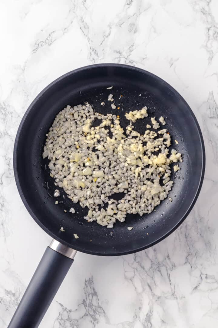 Onion and garlic cooking in skillet