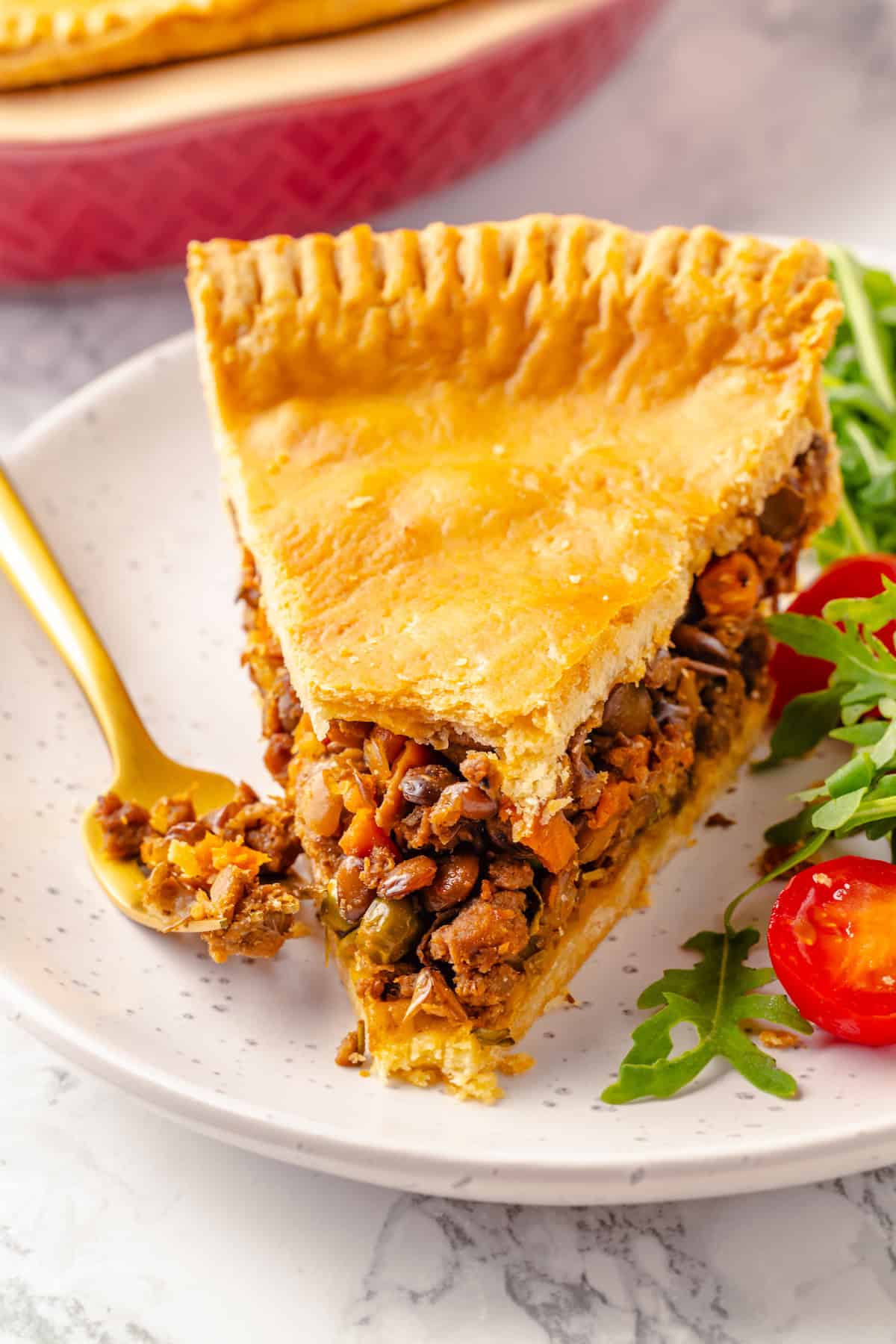 Tourtière slice on plate with salad