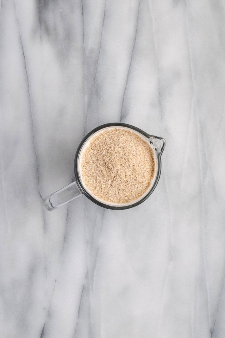 Psyllium husk added to milk and water in measuring cup