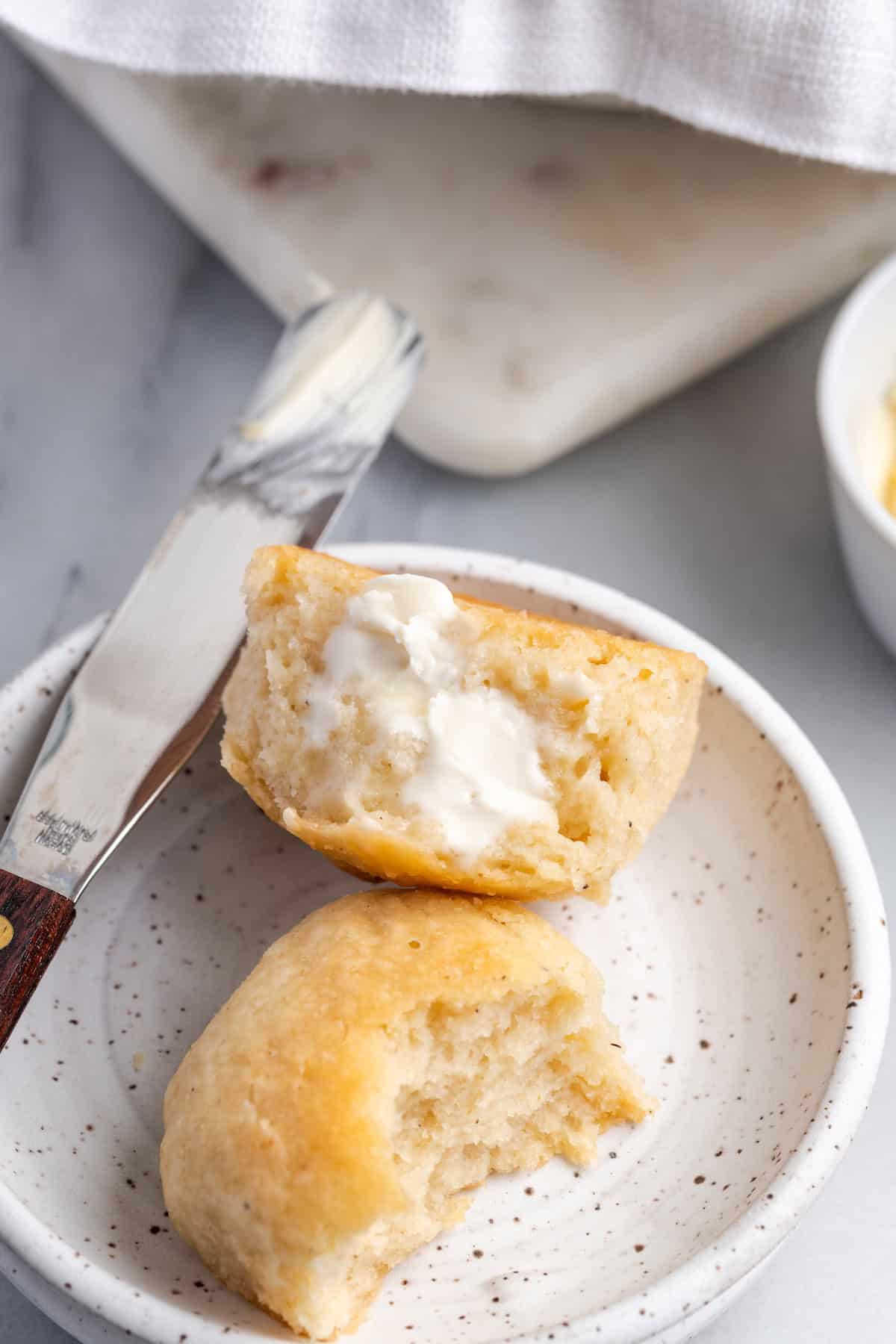 Vegan gluten-free dinner rolls on plate with butter