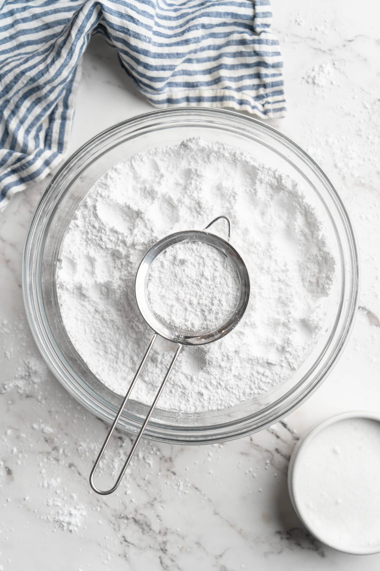 Homemade powdered sugar in bowl with sifter