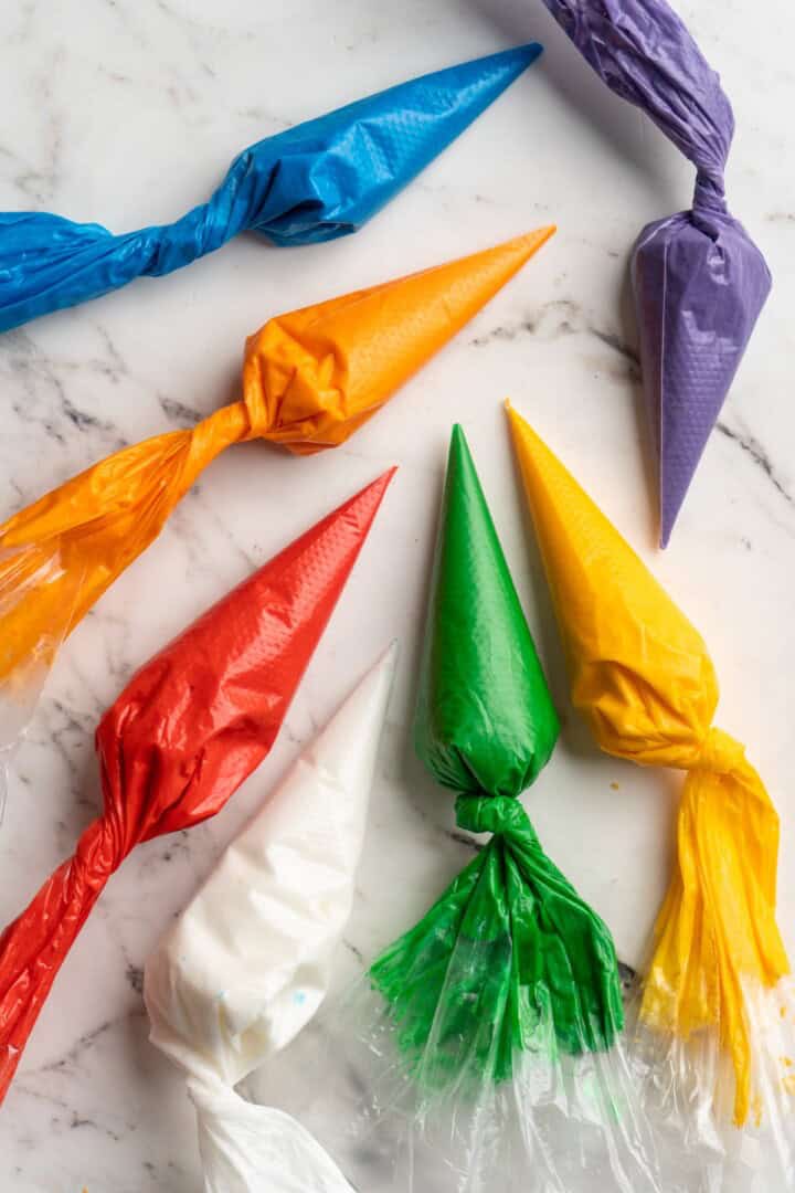 Overhead view of coloured icing in piping bags