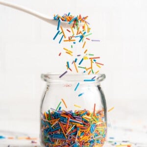 Spoonful of homemade sprinkles held over jar